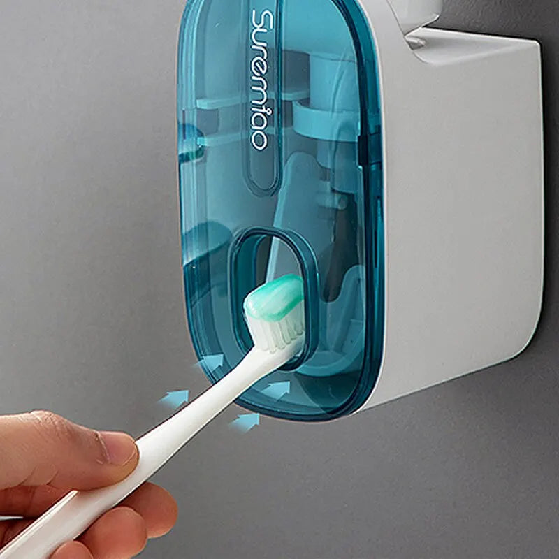 WinniHouse automatic toothpaste dispenser showing a sleek white device squeezing toothpaste onto a toothbrush.